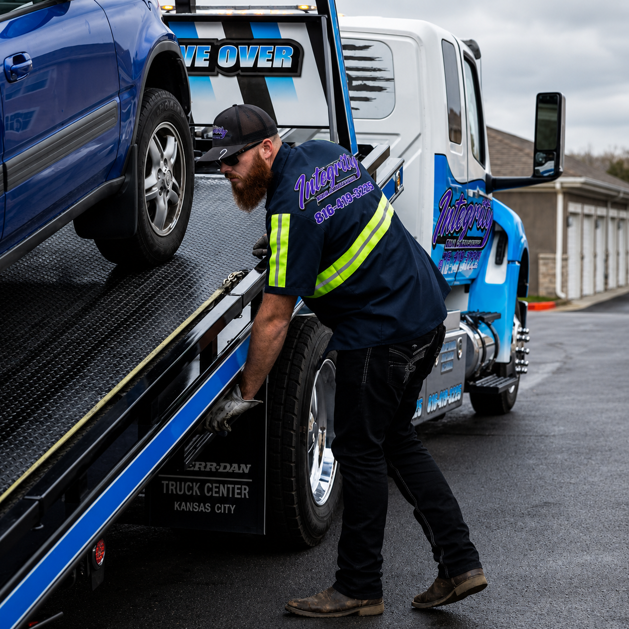 Integrity Tow & Recovery operator securing an SUV on a flatbed in Kansas City